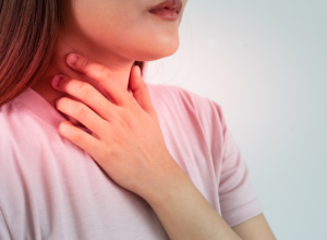 換気不足で室内に有害物質がたまりシックハウス症候群でのどが痛い女性